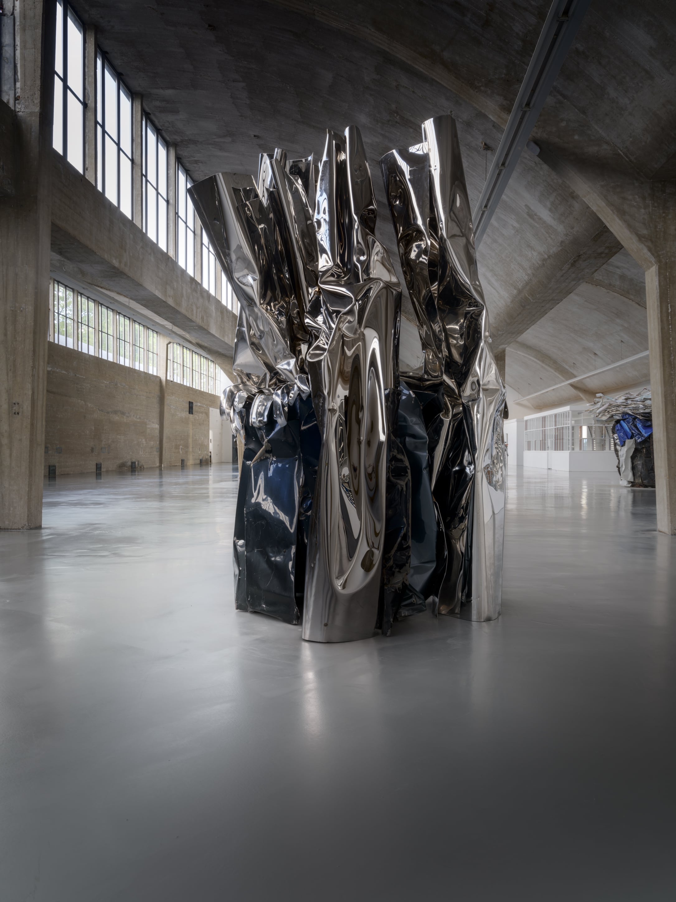 ZAMU Amsterdam sculpture by American sculptor John Chamberlain: art of assemblage, scrap metal, plated and crushed metal, silver and blue colors, industrial concrete building, polished floor